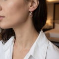 Woman wearing the Swan Baltic Honey Amber Earrings in Sterling Silver, showcasing genuine honey Baltic amber and polished 925 sterling silver in an elegant luxury jewelry lifestyle setting.