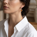 Woman wearing the Amy Baltic Honey Amber Earrings in Sterling Silver, showcasing genuine honey Baltic amber and polished 925 sterling silver in an elegant luxury jewelry lifestyle setting.