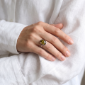 Woman wearing the Dana Baltic Green Amber Ring in Sterling Silver, showcasing genuine green Baltic amber and polished 925 sterling silver in an elegant luxury jewelry lifestyle setting.