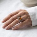 Woman wearing the Dara Baltic Honey Amber Ring in Sterling Silver, showcasing genuine honey Baltic amber and polished 925 sterling silver in an elegant luxury jewelry lifestyle setting.