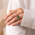 Woman wearing the Cora Baltic Green Amber Ring in Sterling Silver, showcasing genuine green Baltic amber and polished 925 sterling silver in an elegant luxury jewelry lifestyle setting.
