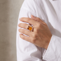 Woman wearing the Baltic Honey Amber Rectangle Ring in Sterling Silver, showcasing genuine honey Baltic amber and polished 925 sterling silver in an elegant luxury jewelry lifestyle setting.