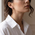 Woman wearing the Gina Baltic Honey Amber Earrings in Sterling Silver, showcasing genuine honey Baltic amber and polished 925 sterling silver in an elegant luxury jewelry lifestyle setting.