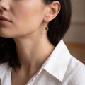 Woman wearing the Rose Baltic Honey Amber Earrings in Sterling Silver, showcasing genuine honey Baltic amber and polished 925 sterling silver in an elegant luxury jewelry lifestyle setting.