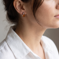 Woman wearing the Baltic Honey Amber Stud Drop Earrings in Sterling Silver, showcasing genuine honey Baltic amber and polished 925 sterling silver in an elegant luxury jewelry lifestyle setting.
