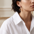Woman wearing the Rosalie Baltic Honey Amber Earrings in Sterling Silver, showcasing genuine honey Baltic amber and polished 925 sterling silver in an elegant luxury jewelry lifestyle setting.