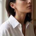 Woman wearing the Matilda Baltic Honey Amber Earrings in Sterling Silver, showcasing genuine honey Baltic amber and polished 925 sterling silver in an elegant luxury jewelry lifestyle setting.