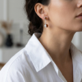 Woman wearing the Baltic Honey Amber Soccer Ball Drop Stud Earrings in Sterling Silver, showcasing genuine honey Baltic amber and polished 925 sterling silver in an elegant luxury jewelry lifestyle setting.