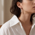 Woman wearing the Eva Baltic Honey Amber Earrings in Sterling Silver, showcasing genuine honey Baltic amber and polished 925 sterling silver in an elegant luxury jewelry lifestyle setting.