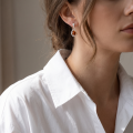 Woman wearing the Peyton Baltic Honey Amber Earrings in Sterling Silver, showcasing genuine honey Baltic amber and polished 925 sterling silver in an elegant luxury jewelry lifestyle setting.