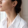 Woman wearing the Catalina Baltic Honey Amber Earrings in Sterling Silver, showcasing genuine honey Baltic amber and polished 925 sterling silver in an elegant luxury jewelry lifestyle setting.