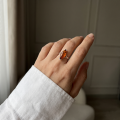 Woman wearing the Harriet Baltic Honey Amber Marquise Ring in Sterling Silver, showcasing genuine marquise-cut honey Baltic amber and polished 925 sterling silver in an elegant luxury jewelry lifestyle setting.