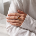 Woman wearing the Maggie Baltic Honey Amber Oval Ring in Sterling Silver, showcasing genuine oval honey Baltic amber and polished 925 sterling silver in an elegant luxury jewelry lifestyle setting.
