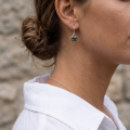 Woman wearing the Jane Baltic Green Amber Earrings in Sterling Silver, showcasing genuine green Baltic amber and polished 925 sterling silver in an elegant luxury jewelry lifestyle setting.