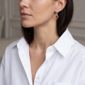 Woman wearing the Helmi Baltic Honey Amber Earrings in Sterling Silver, showcasing genuine honey Baltic amber and polished 925 sterling silver in an elegant luxury jewelry lifestyle setting.