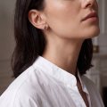 Woman wearing the Ilona Baltic Honey Amber Earrings in Sterling Silver, showcasing genuine honey Baltic amber and polished 925 sterling silver in an elegant luxury jewelry lifestyle setting.