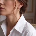 Woman wearing the Emilia Baltic Honey Amber Earrings in Sterling Silver, showcasing genuine honey Baltic amber and polished 925 sterling silver in an elegant luxury jewelry lifestyle setting.