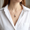 Woman wearing the Owl Baltic Amber Pendant in Sterling Silver, showcasing genuine Baltic amber and polished 925 sterling silver in an elegant luxury jewelry lifestyle setting.