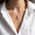 Woman wearing the Aleta Baltic Amber Pendant in Sterling Silver, showcasing genuine Baltic amber and polished 925 sterling silver in an elegant luxury jewelry lifestyle setting.