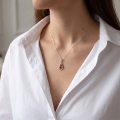 Woman wearing the Baltic Honey Amber Teardrop Pendant Necklace in Sterling Silver, showcasing genuine honey Baltic amber and polished 925 sterling silver in an elegant luxury jewelry lifestyle setting.