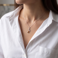 Woman wearing the Swan Baltic Amber Pendant in Sterling Silver, showcasing genuine Baltic amber and polished 925 sterling silver in an elegant luxury jewelry lifestyle setting.