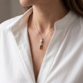 Woman wearing the Eva Baltic Honey Amber Pendant in Sterling Silver, showcasing genuine honey Baltic amber and polished 925 sterling silver in an elegant luxury jewelry lifestyle setting.