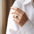 Woman wearing the Baltic Green Amber Square Ring in Sterling Silver, showcasing genuine green Baltic amber and polished 925 sterling silver in an elegant luxury jewelry lifestyle setting.