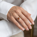 Woman wearing the Loving Heart Baltic Honey Amber Ring in Sterling Silver, showcasing genuine honey Baltic amber and polished 925 sterling silver in an elegant luxury jewelry lifestyle setting.
