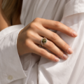 Woman wearing the Hazel Baltic Green Amber Ring in Sterling Silver, showcasing genuine green Baltic amber and polished 925 sterling silver in an elegant luxury jewelry lifestyle setting.