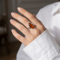 Woman wearing the Athena Baltic Honey Amber Ring in Sterling Silver, showcasing genuine honey Baltic amber and polished 925 sterling silver in an elegant luxury jewelry lifestyle setting.