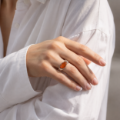 Woman wearing the Baltic Honey Amber Contemporary Ring in Sterling Silver, showcasing genuine honey Baltic amber and polished 925 sterling silver in an elegant luxury jewelry lifestyle setting.