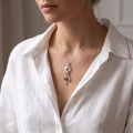 Woman wearing the Baltic Amber Heart Pendant in Sterling Silver, showcasing genuine Baltic amber and polished 925 sterling silver in an elegant luxury jewelry lifestyle setting.