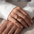 Woman wearing the Federica Baltic Honey Amber Ring in Sterling Silver, showcasing genuine honey Baltic amber and polished 925 sterling silver in an elegant luxury jewelry lifestyle setting.