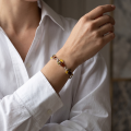 Woman wearing the April Baltic Amber Bracelet in Sterling Silver, showcasing genuine Baltic amber and polished 925 sterling silver in an elegant luxury jewelry lifestyle setting.