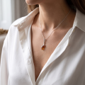 Woman wearing the Alicia Baltic Amber Pendant in Sterling Silver, showcasing genuine Baltic amber and polished 925 sterling silver in an elegant luxury jewelry lifestyle setting.