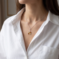 Woman wearing the Clover Baltic Amber Pendant in Sterling Silver, showcasing genuine Baltic amber and polished 925 sterling silver in an elegant luxury jewelry lifestyle setting.