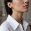 Woman wearing the Avery Baltic Honey Amber Earrings in Sterling Silver, showcasing genuine honey Baltic amber and polished 925 sterling silver in an elegant luxury jewelry lifestyle setting.