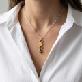 Woman wearing the Anna Multicolor Baltic Amber Pendant in Sterling Silver, showcasing genuine multicolor Baltic amber and polished 925 sterling silver in an elegant luxury jewelry lifestyle setting.