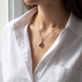 Woman wearing the Cat Baltic Honey Amber Pendant in Sterling Silver, showcasing genuine honey Baltic amber and polished 925 sterling silver in an elegant luxury jewelry lifestyle setting.