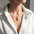 Woman wearing the Baltic Honey Amber Cat Pendant Necklace in Sterling Silver, showcasing genuine honey Baltic amber and polished 925 sterling silver in an elegant luxury jewelry lifestyle setting.
