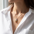 Woman wearing the Coral Reef Multicolor Baltic Amber Pendant in Sterling Silver, showcasing genuine multicolor Baltic amber and polished 925 sterling silver in an elegant luxury jewelry lifestyle setting.