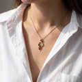 Woman wearing sterling silver multicolor Baltic amber pendant “April” necklace with genuine honey, golden yellow and forest green amber stones on 18 inch chain