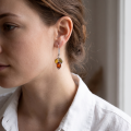 Model wearing genuine Baltic amber drop earrings in 925 sterling silver with multicolor amber stones, lightweight handcrafted earrings made in Poland