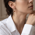 Woman wearing the Baltic Honey Amber Drop Earrings in Sterling Silver, showcasing genuine honey Baltic amber and polished 925 sterling silver in an elegant luxury jewelry lifestyle setting.
