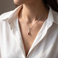 Woman wearing the Elegance Baltic Honey Amber Pendant in Sterling Silver, showcasing genuine honey Baltic amber and polished 925 sterling silver in an elegant luxury jewelry lifestyle setting.