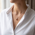 Woman wearing the Aine Baltic Honey Amber Oval Pendant in Sterling Silver, showcasing genuine honey Baltic amber and polished 925 sterling silver in an elegant luxury jewelry lifestyle setting.