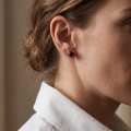 Woman wearing the Sadie Cherry Baltic Amber Earrings in Sterling Silver, showcasing genuine cherry Baltic amber and polished 925 sterling silver in an elegant luxury jewelry lifestyle setting.