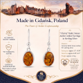 Woman wearing the Christy Baltic Honey Amber Earrings in Sterling Silver, showcasing genuine honey Baltic amber and polished 925 sterling silver in an elegant luxury jewelry lifestyle setting.