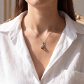 Woman wearing the Aurelia Baltic Amber Pendant in Sterling Silver, showcasing genuine Baltic amber and polished 925 sterling silver in an elegant luxury jewelry lifestyle setting.