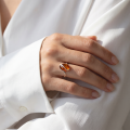 Woman wearing the Sunshine Baltic Honey Amber Adjustable Ring in Sterling Silver, showcasing genuine honey Baltic amber and polished 925 sterling silver in an elegant luxury jewelry lifestyle setting.